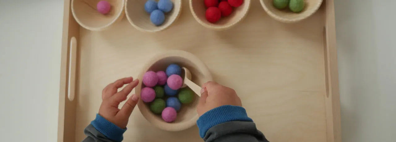 Filzkugeln in verschiedenen Schüsseln werden sortiert